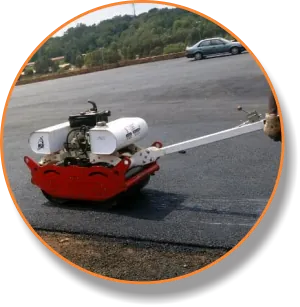 Plate compactor working on a newly patched road surface