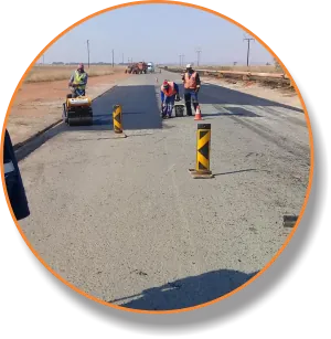 Roller and crew finishing a patched road section