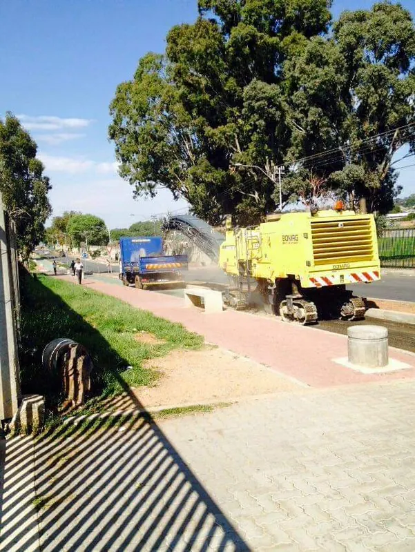 Wirtgen milling machine working next to a brick-paved walkway