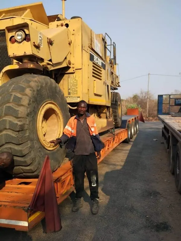 Team member beside a milling machine on a low-bed truck