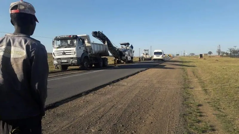 Milling machine and tipper truck working on a road